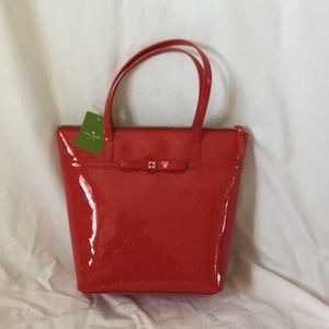 Red patent leather purse with polka dot imprint.